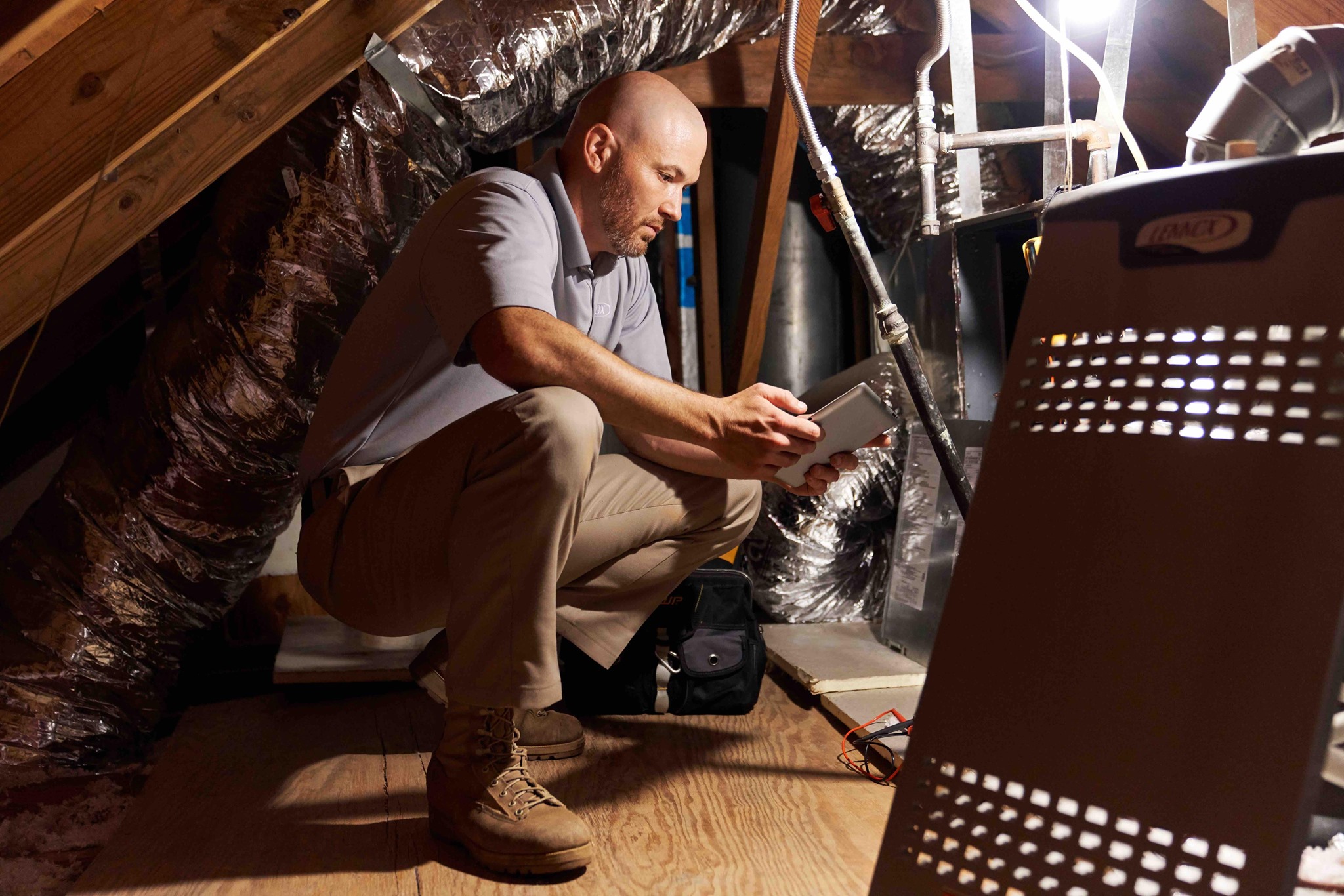HVAC technician inspecting a home furnace in San Diego County